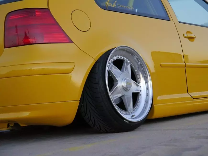 OEM alloy wheels on a yellow car