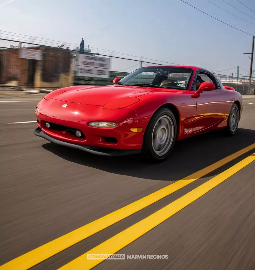 A red 1995 Mazda RX7 FD shot by Stance Auto Magazine Photographers driving down the freeway