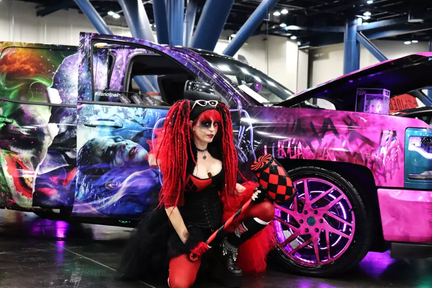 Girl dressed in cosplay at the side of a car