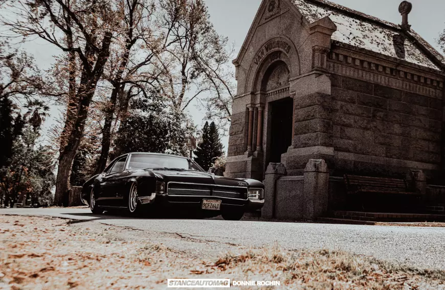 A of a lowrider 1967 Buick Riviera 'Deathwish'  shot by stance auto magazine photogrpahers at the entrence of a church