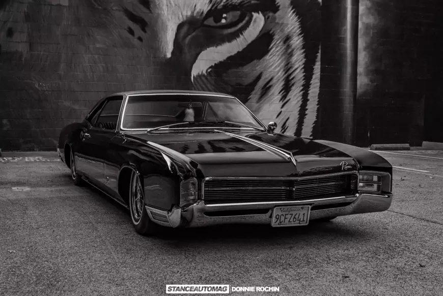 A 1967 Buick Riviera 'Deathwish'  pictured infront of a lion painted on a wall