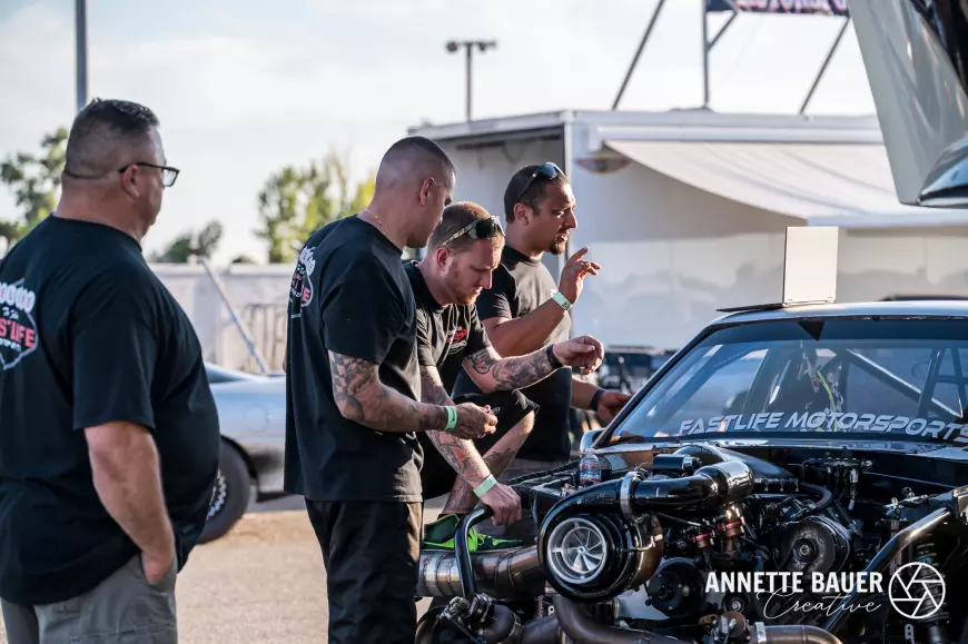 Mchanics looking over the engine of a drag racing car
