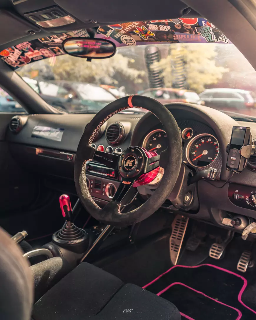 The interior of a Pink 2001 Audi TT with silver wheels 