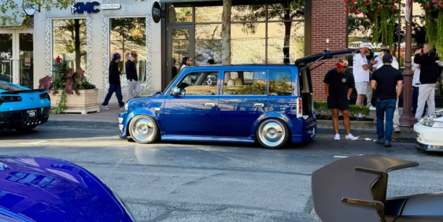 Bagged Toyota bB in blue with Modellista Yakuza bumper, Work wheels and Highworks Garage rear mid wing